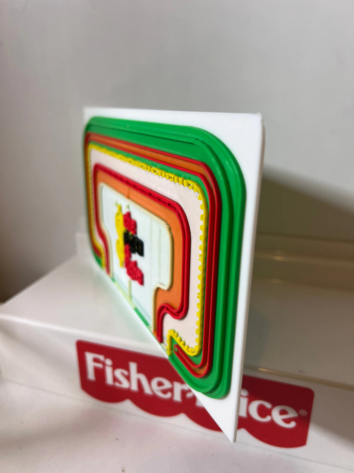Game show backdrop panel with green-red outline design and Fisher-Price branded strip