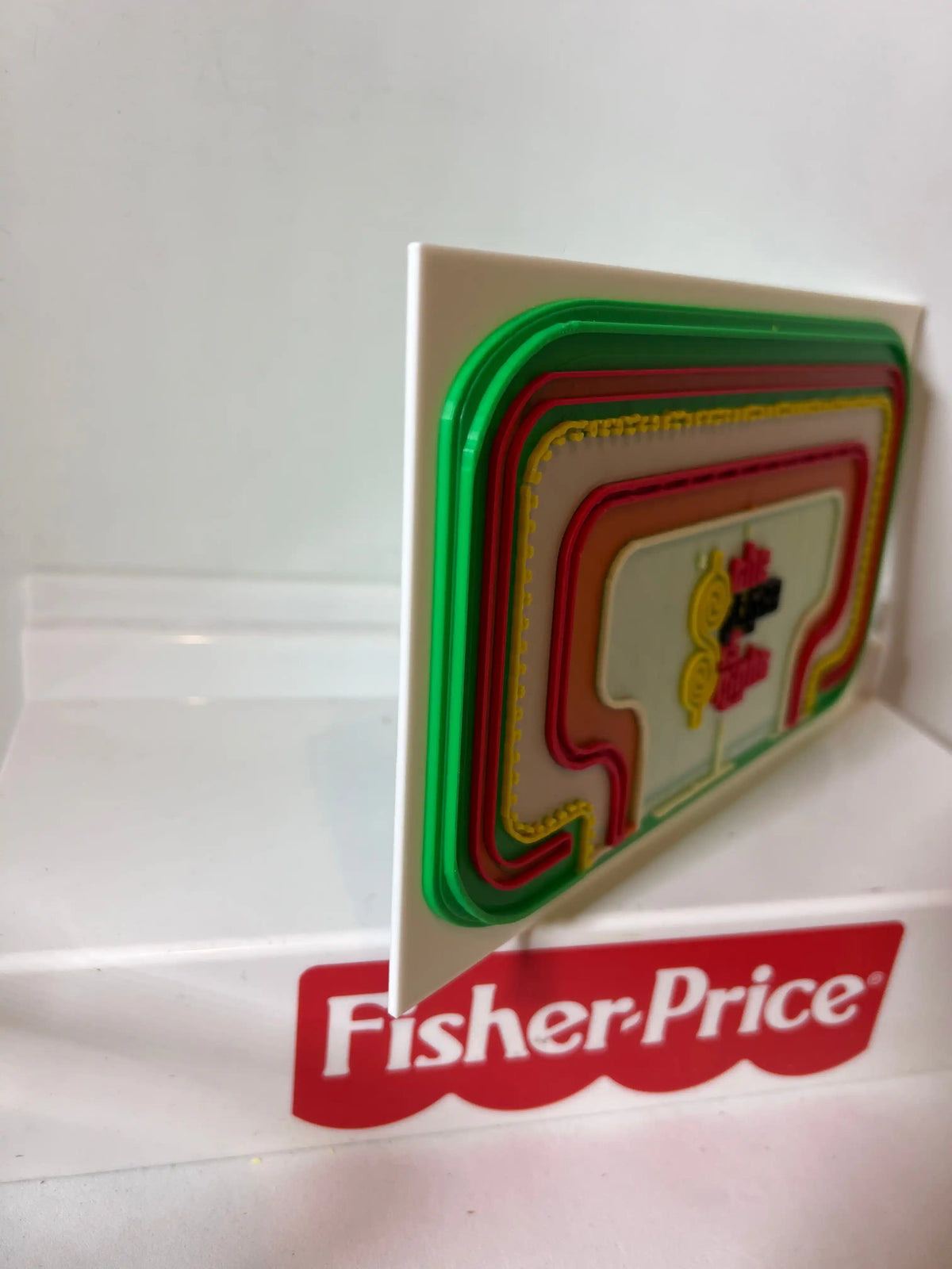 Game show style backdrop panel with green and red border and Fisher-Price logo strip