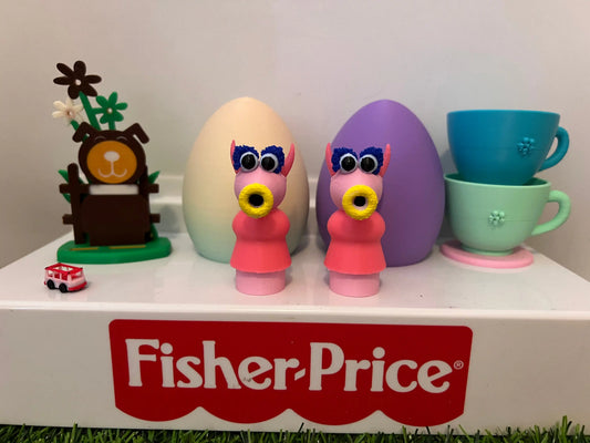 Two pink custom 3D-printed Fisher-Price Muppet Snowths stand with a dog figure and teacups