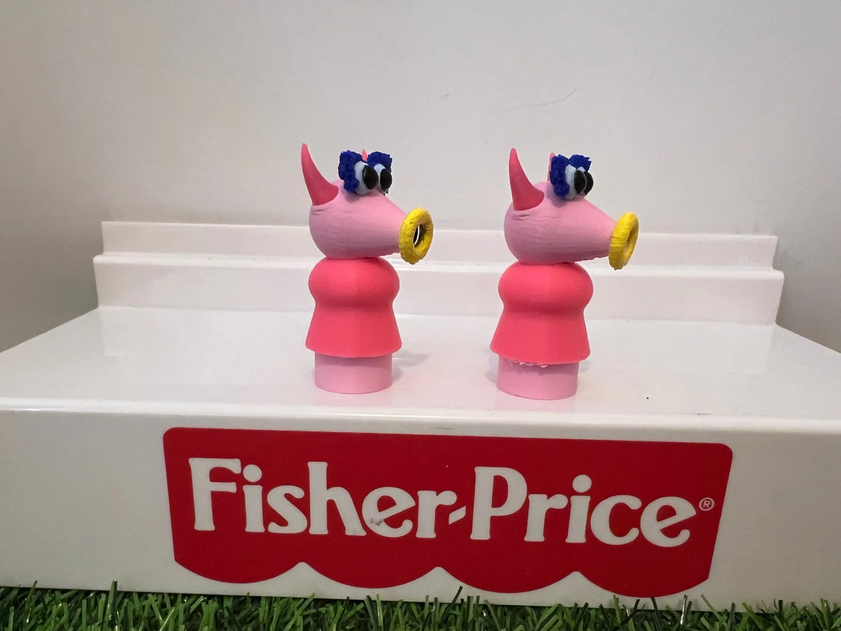 Two standing muppet-style toy figurines, side view with blue hair and red skirt