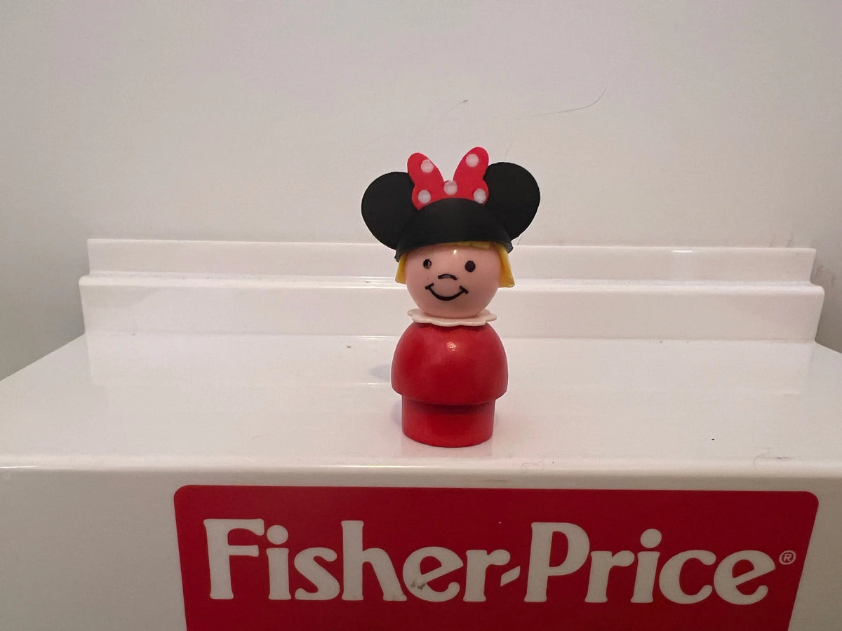 Minnie-style mouse ear hat on smiling figurine with red outfit