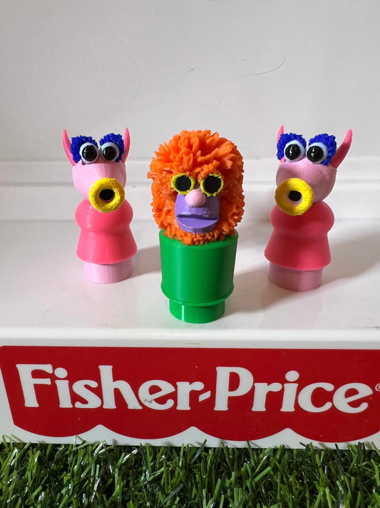 A custom 3D-printed Muppets Mahna Mahna figure, with two pink cow figures, stands on a Fisher-Price toy.