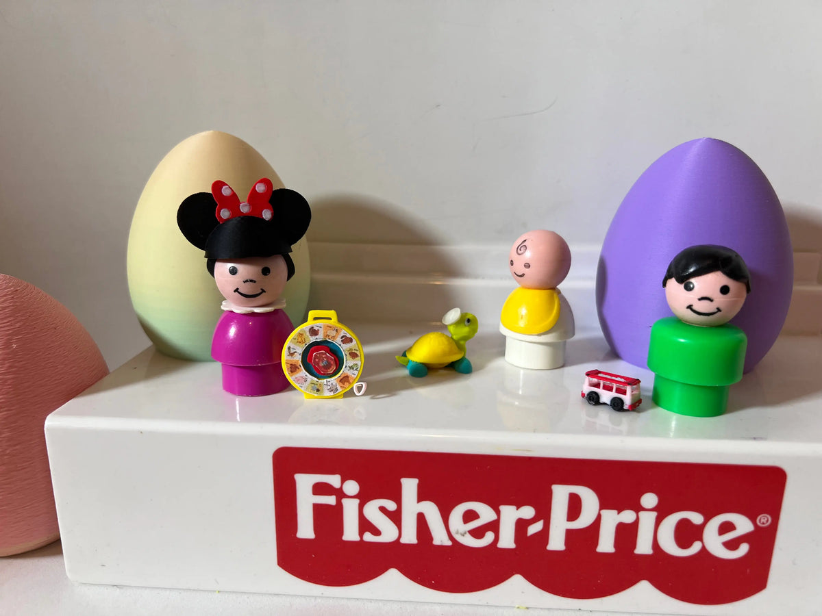 Miniature toy figurines on white shelf with small green turtle and red bus