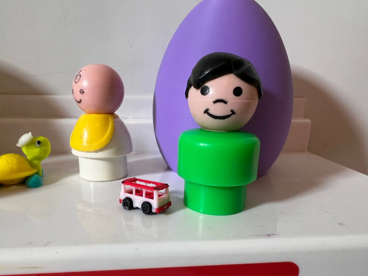 Custom miniature toys, including a red and white bus, a green turtle, a baby figure, and a boy figure, on a white surface.