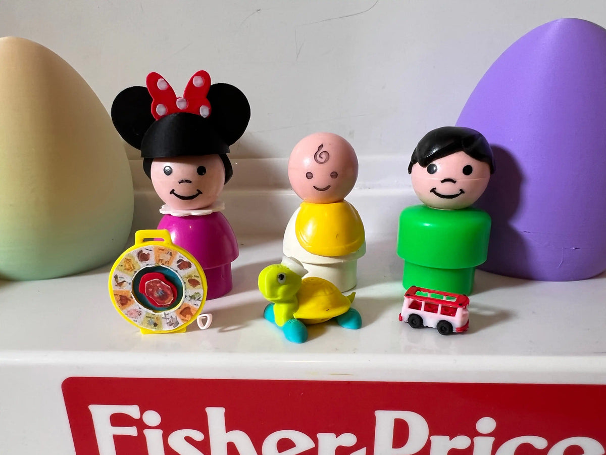 A custom Minnie Mouse Little People figure, a baby, and a man stand next to a See 'n Say, a turtle, and a bus.