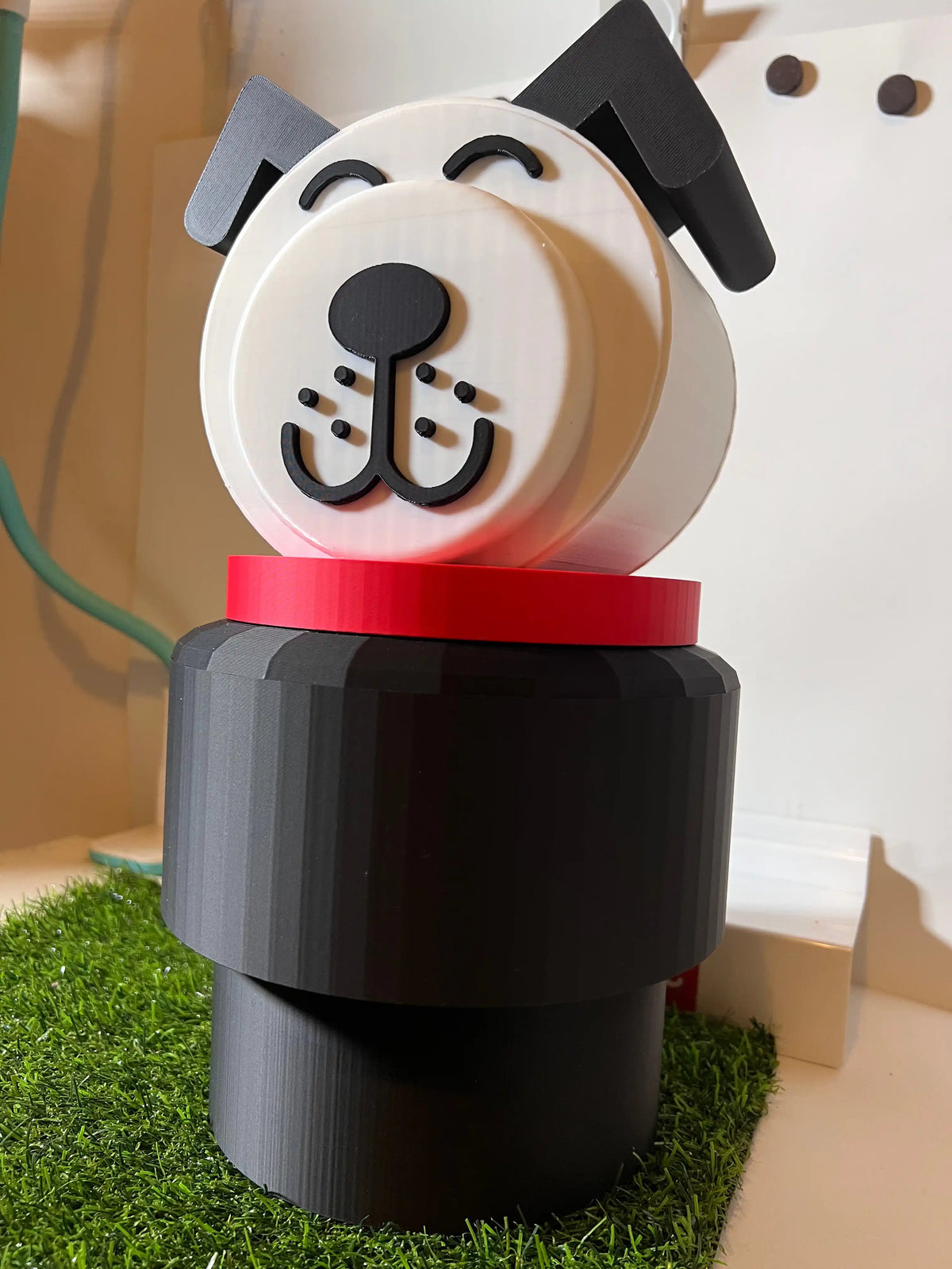A jumbo custom Fisher-Price Lucky/Fido figure with a white dog head, red collar, and black base on artificial grass.