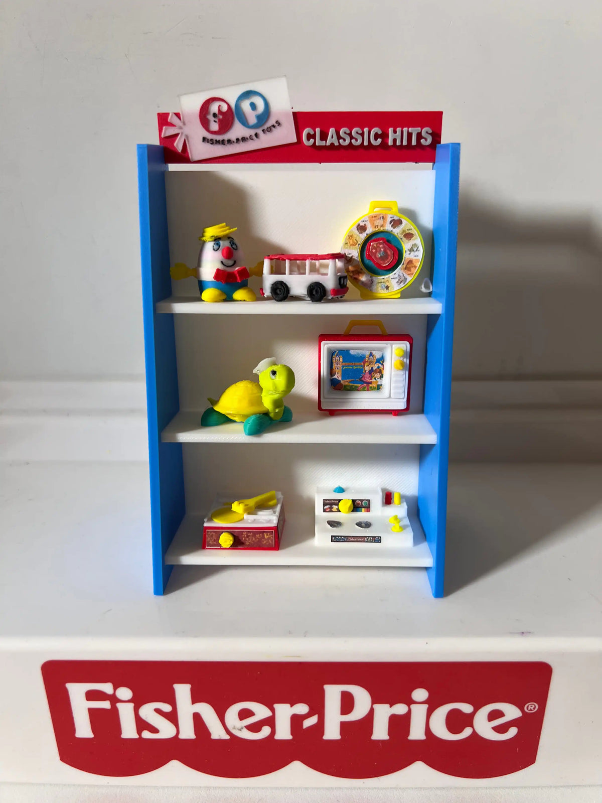 A custom blue and white Fisher-Price display toy shelf showcasing miniature Little People-style figures and accessories.