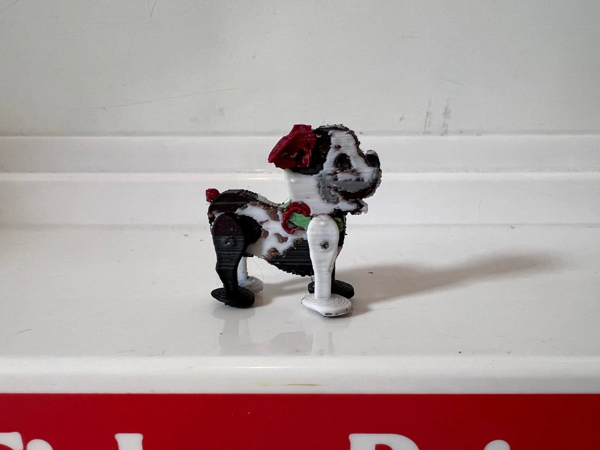 Miniature black-and-white puppy figurine with red bow, standing pose