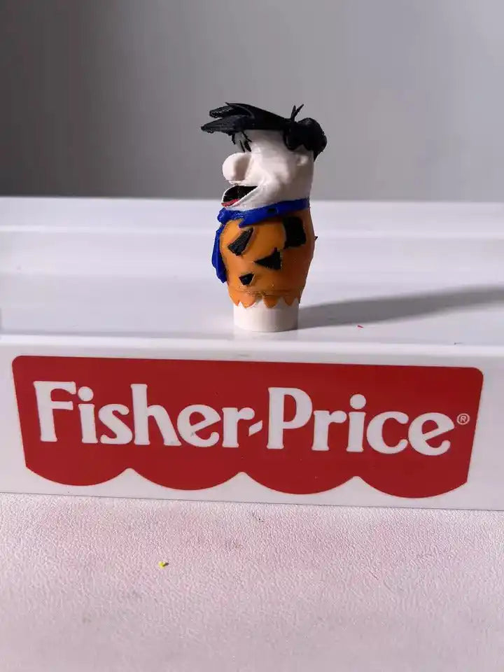 Fred Flintstone toy figure facing left, orange tunic with blue straps