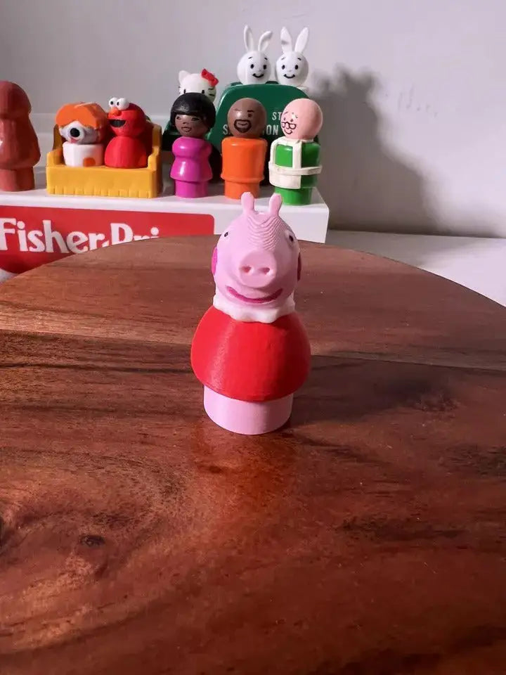 Pink pig figurine in red top and white feet, standing