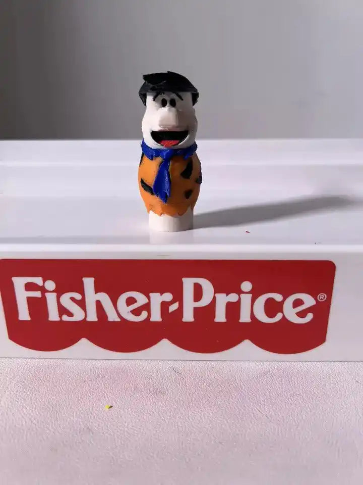 A custom 3D printed Flintstones Fred Little People figure, wearing an orange tunic and blue tie,