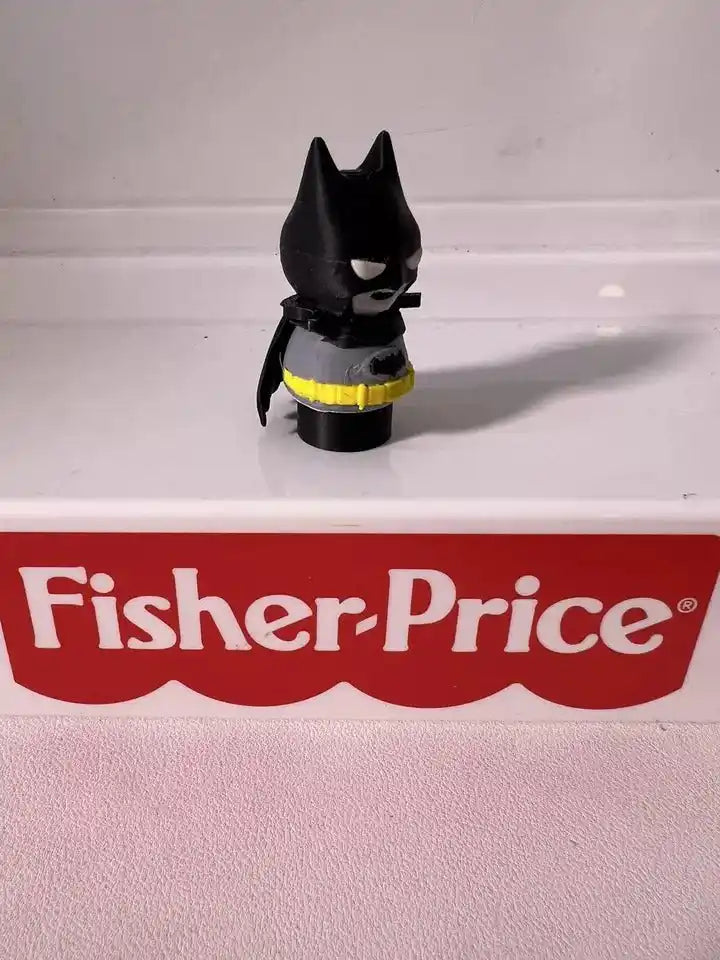 Batman mini figure from side, black cape and yellow belt detail