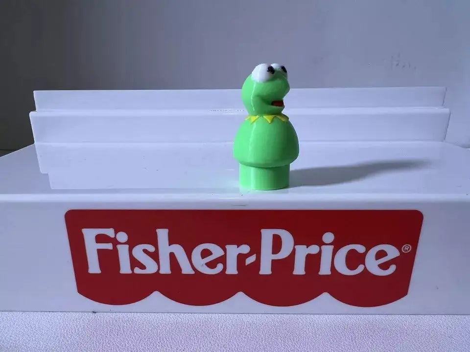 Green frog figurine standing upright with white eyes and open mouth, front view