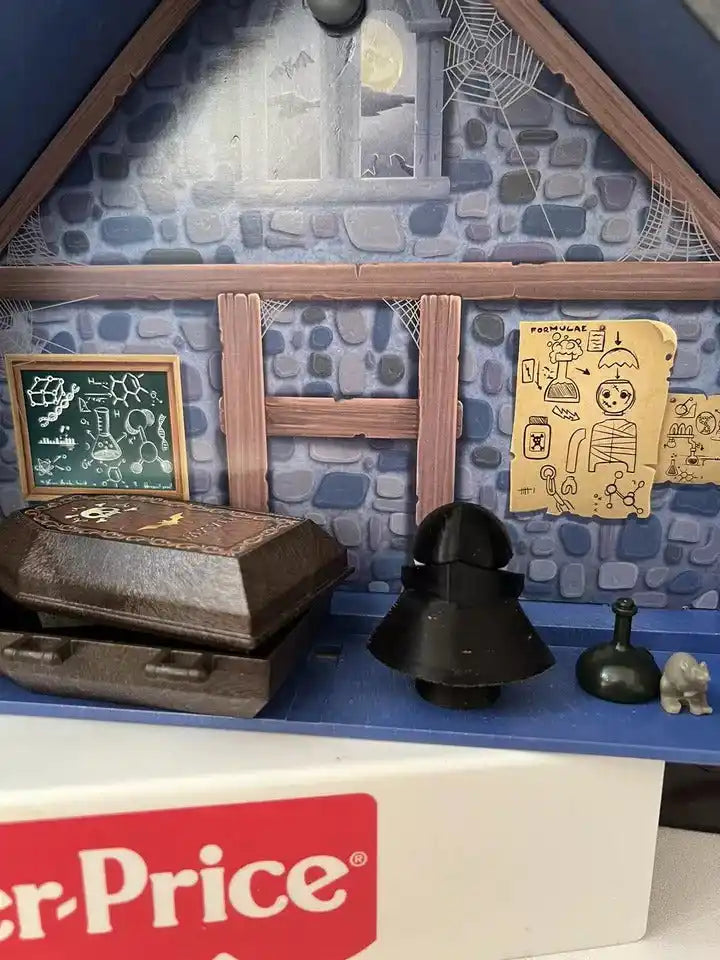 Halloween Dracula-style playset with coffin, portrait frames, and small black cape accessory.