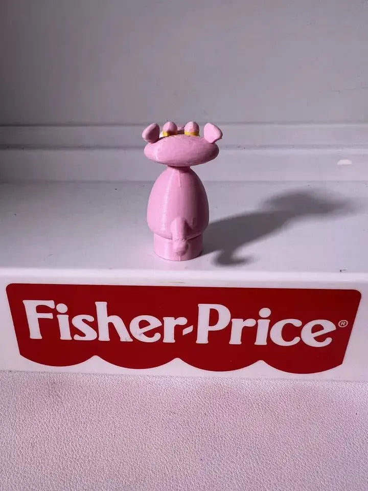 Pink panther toy figurine with yellow crown and purple spots, standing pose