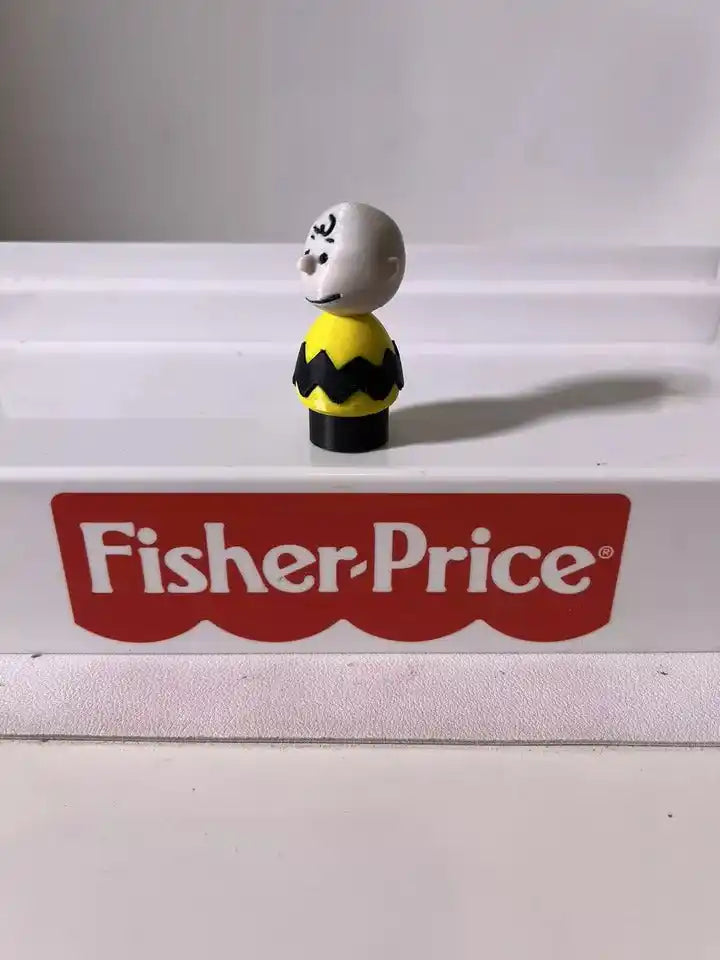 Small standing character figure with gray head and yellow black zigzag outfit