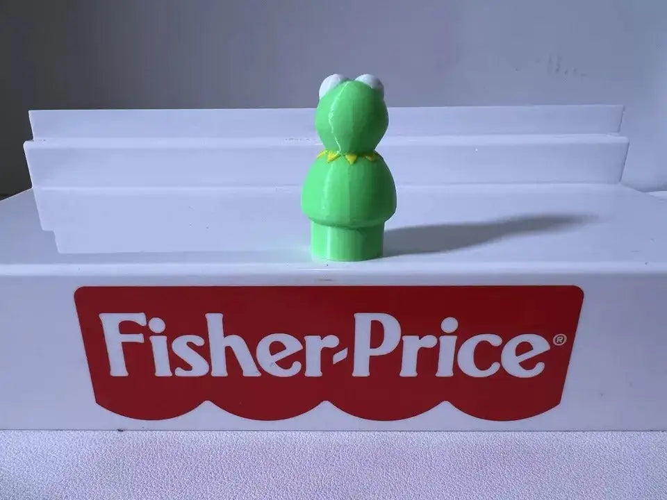 Green frog figurine with white eyes and open mouth, standing with body turned slightly