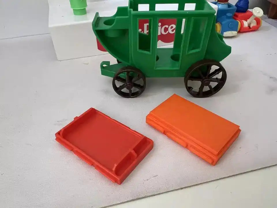 Fisher Price stagecoach wagon with orange roof panels, green body, and two flat pieces