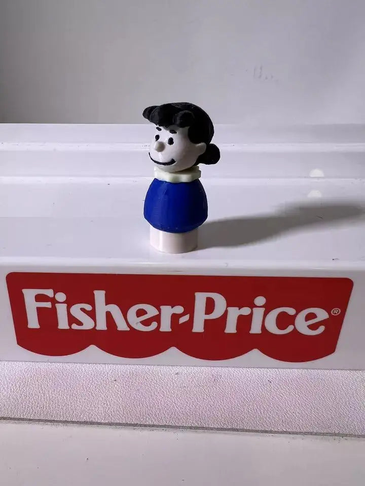 Peanuts Lucy Brown figurine with black hair and blue dress on white base