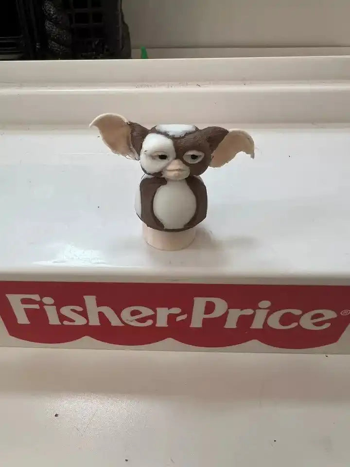 Brown-and-white dog figurine with open-mouth face on round beige base