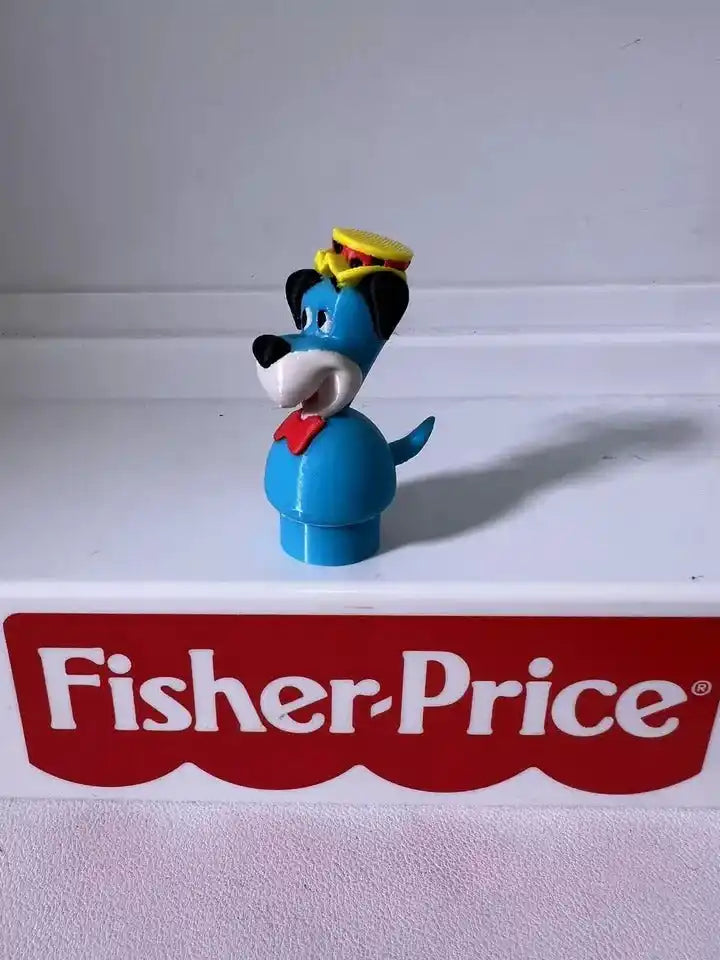 Huckleberry Hound blue dog figurine with yellow hat, red bowtie, arm to the side