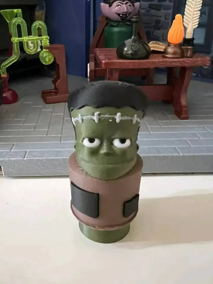 Frankenstein-style green head figurine with black hair and white stitched marks, Halloween decor