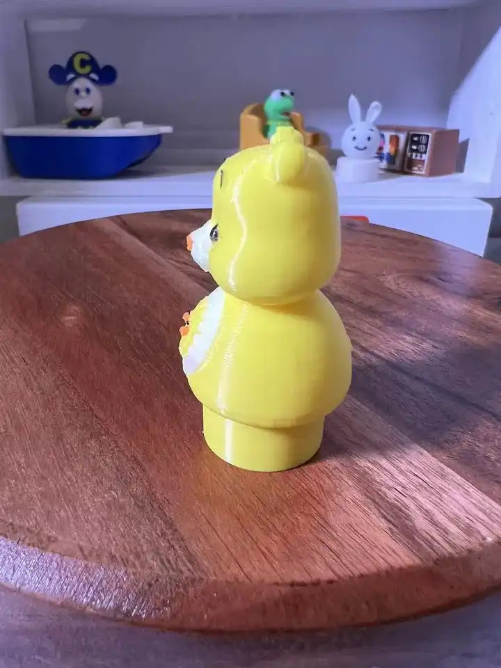 Yellow bear figurine viewed from behind with raised ears and back details