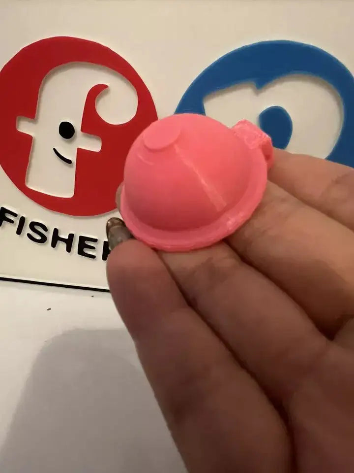 Pink replacement hair dryer nozzle cap side view, held in hand