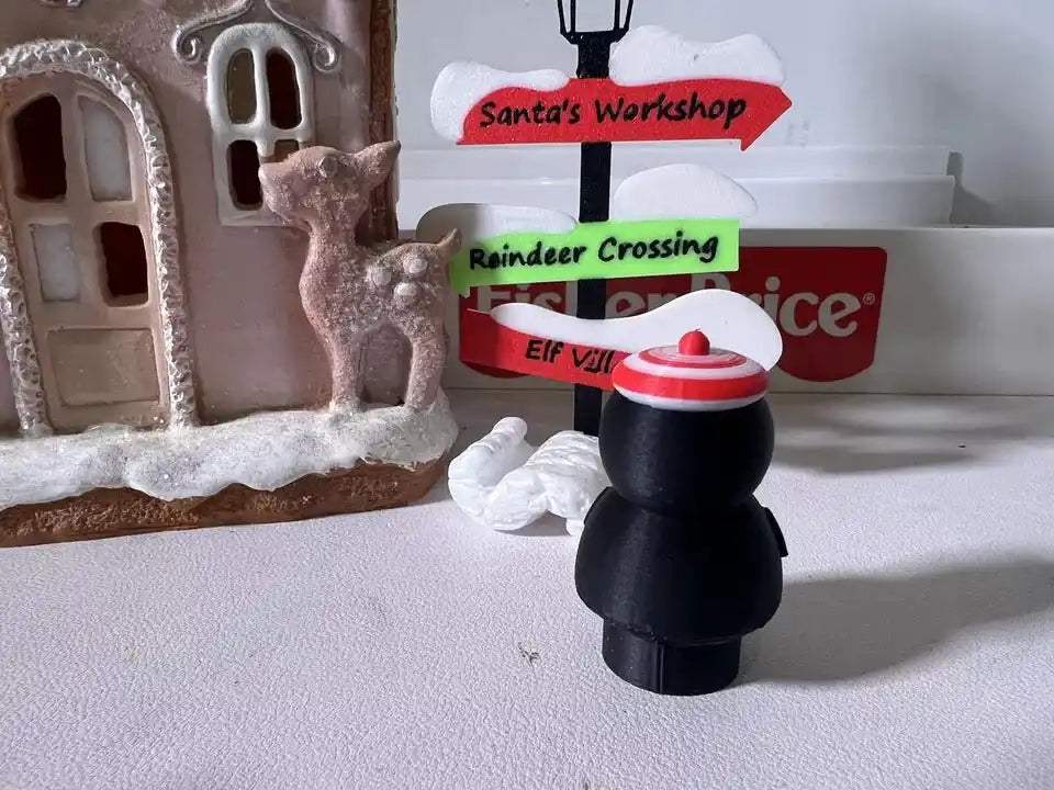 Peppermint penguin holiday figurine with red-and-white hat and standing candy sign
