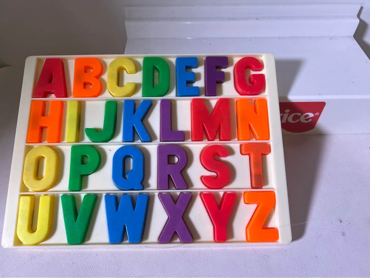 Colorful plastic letter tiles A–Z in beige tray