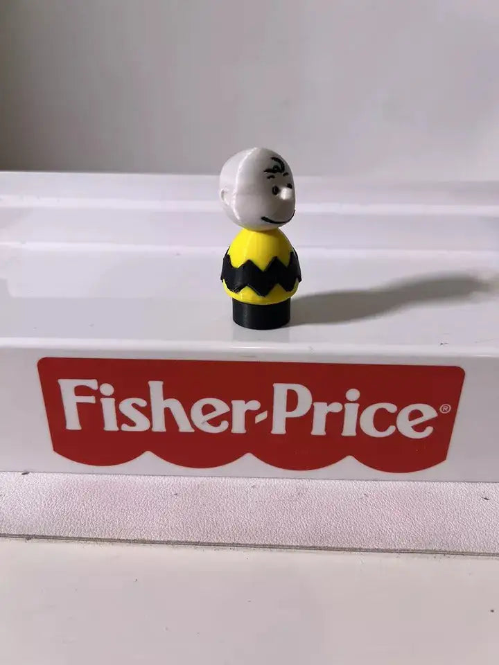 Small character figure with gray head and yellow black zigzag outfit