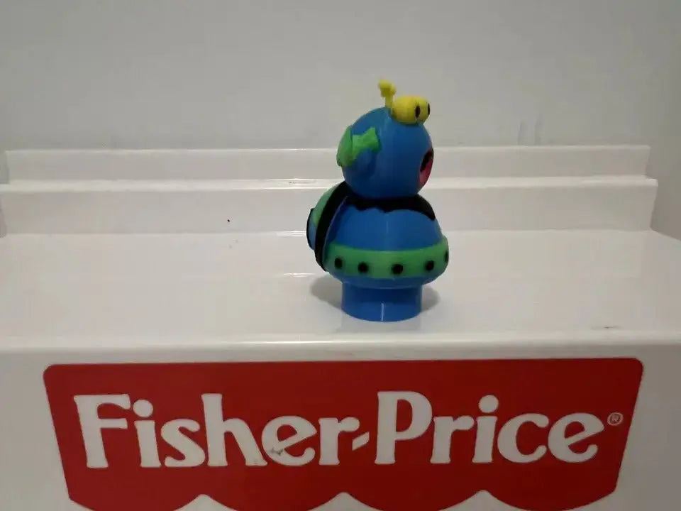 Blue and green bug-style figure in profile view with yellow antennae and red mouth