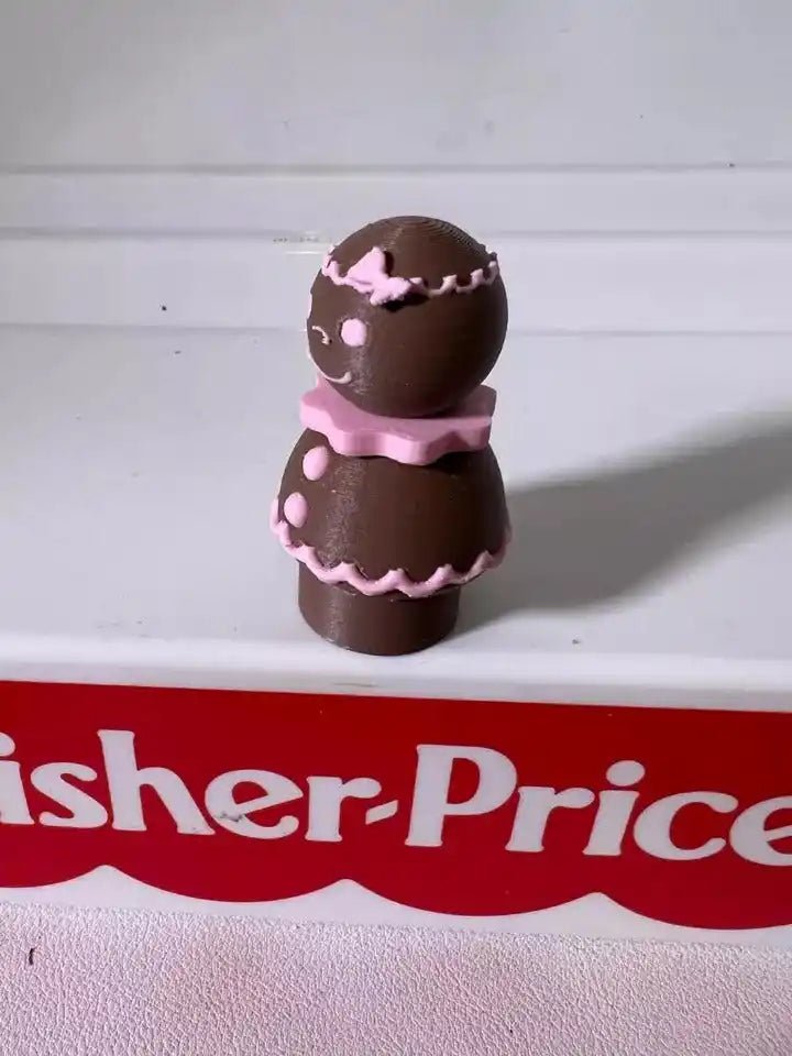 Pink-iced gingerbread pals figurine, two stacked cookies with matching icing details