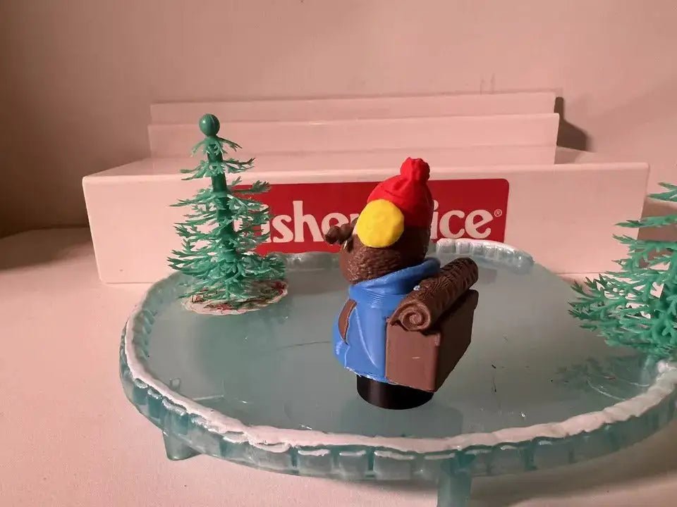 Christmas holiday figurine set with nutcracker holding gift and yellow ornament on icy base