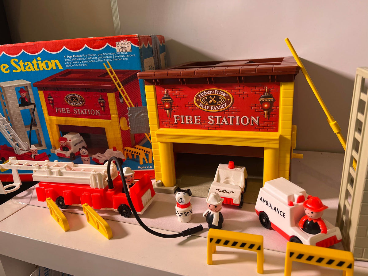 Yellow fire station playset with red roof, ambulance, fire truck, and mini figures