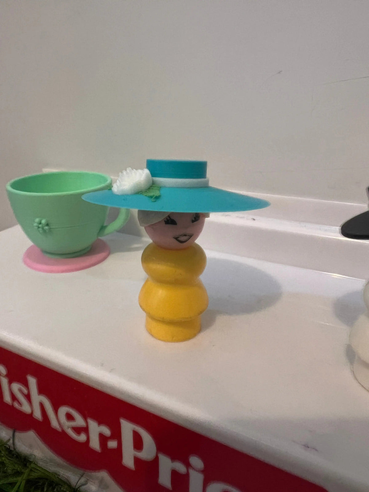 Blue wide-brim derby hat with white flower detail and teal band