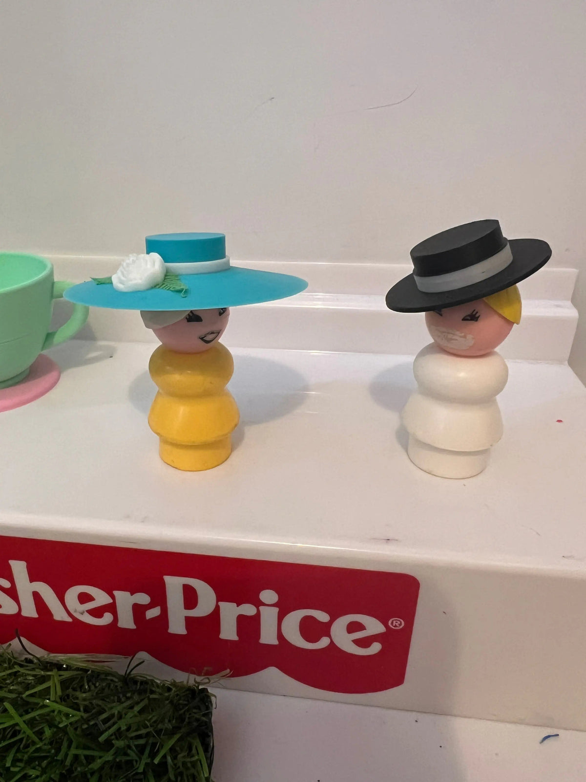 Two custom Fisher-Price Little People style figures, one wearing a Tiffany blue fancy wide-brim Derby hat with flower.