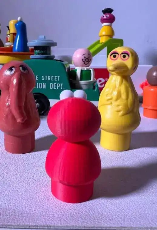 3D-printed cartoon figure: pink character facing yellow character with big eyes