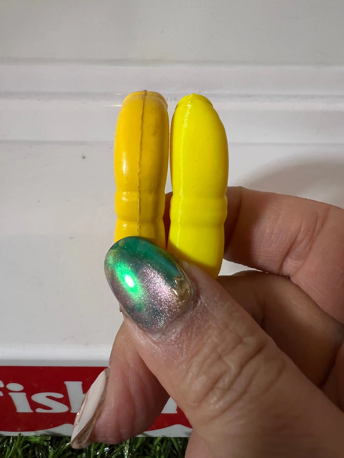 Yellow plastic life preserver replacement rings held in hand, side view