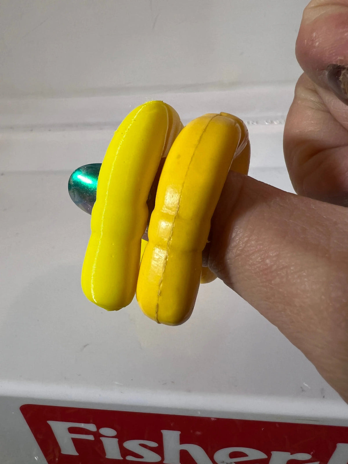 Yellow plastic life preserver replacement rings held in hand, close-up