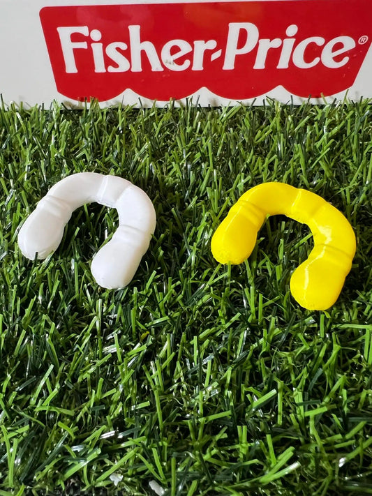 Two custom Fisher-Price replacement life preservers, one white and one yellow, rest on artificial grass.