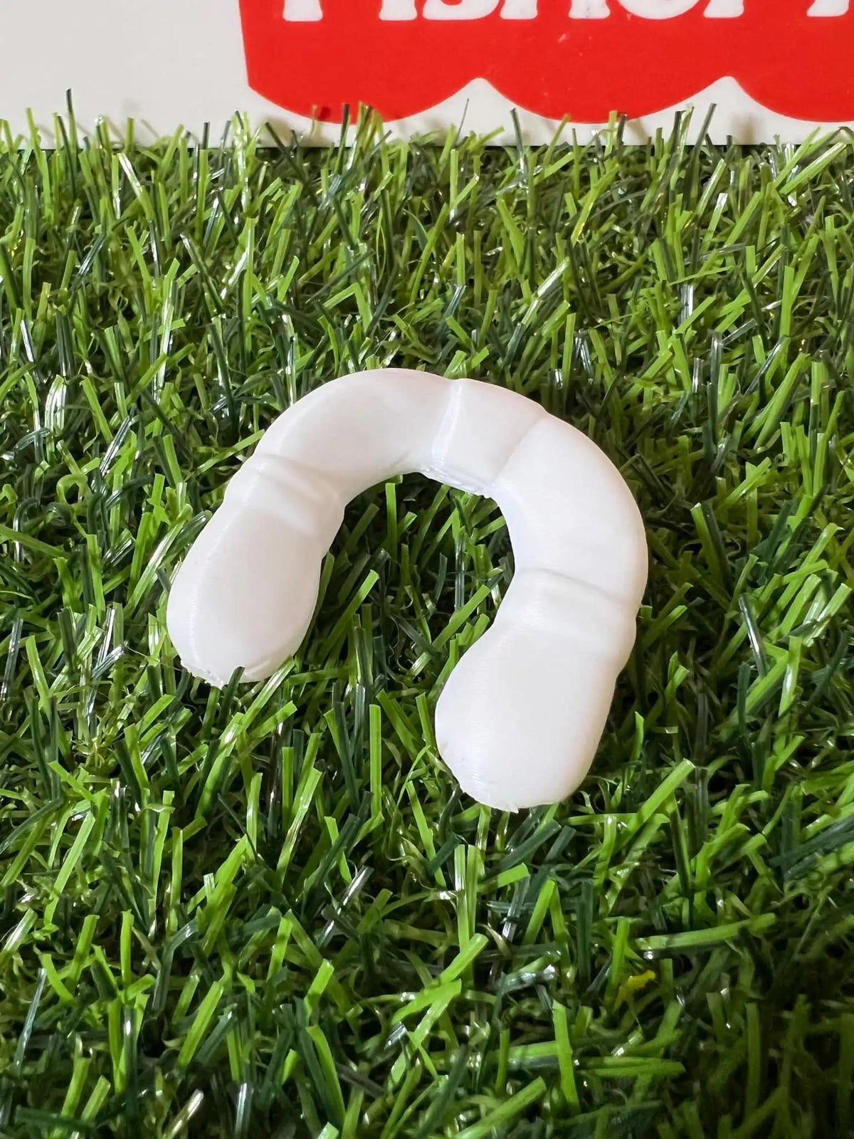 White plastic life preserver replacement ring on artificial grass
