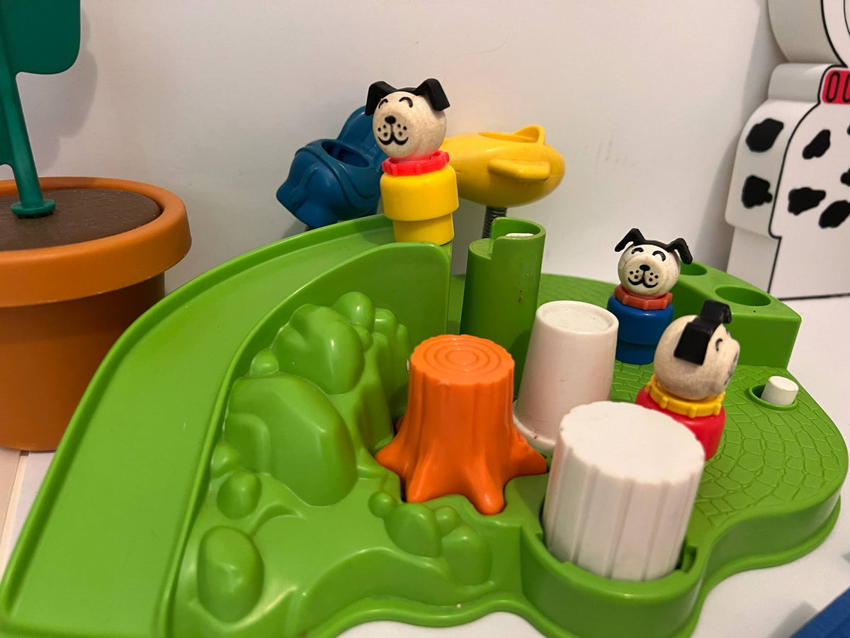 Green play tray with dog figures, orange and white cones, and yellow launcher
