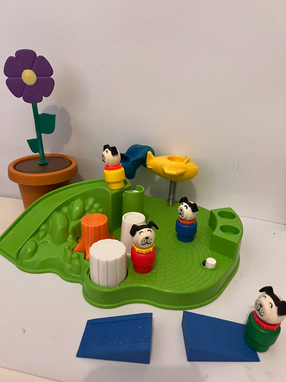Dog toy playset on green base with blue mats, orange cones, and flower accessory