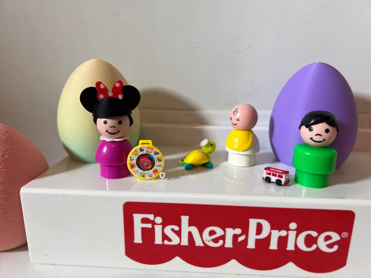 Miniature toy figurines on white shelf with small green turtle and red bus
