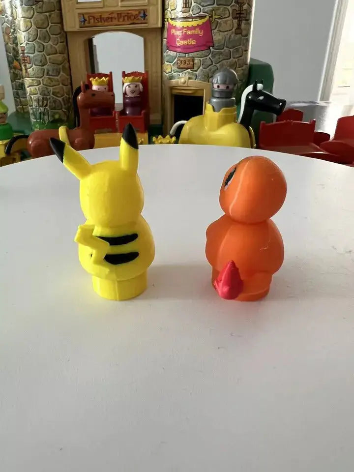 Yellow Pikachu figure turned sideways and orange lizard figure turned sideways