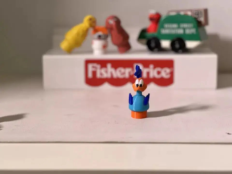 Blue and orange Road Runner-style plastic figure with blue tail and wings, standing