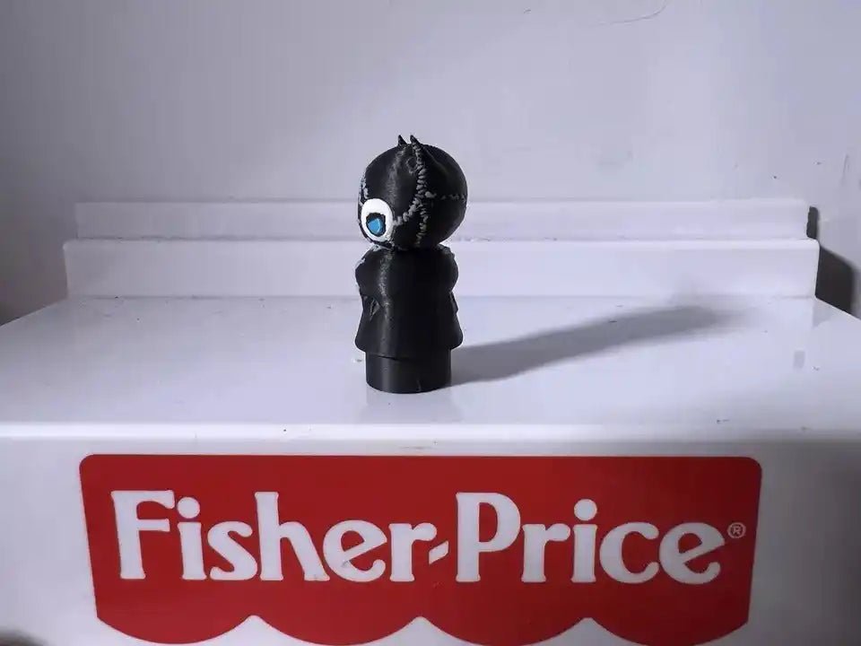 Black cat character figurine with blue eyes and pointed ears, standing facing forward