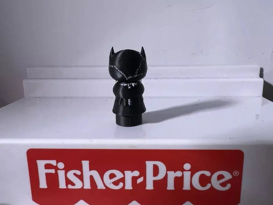 Black cat character figurine with pointed ears and blue eye details, viewed from behind