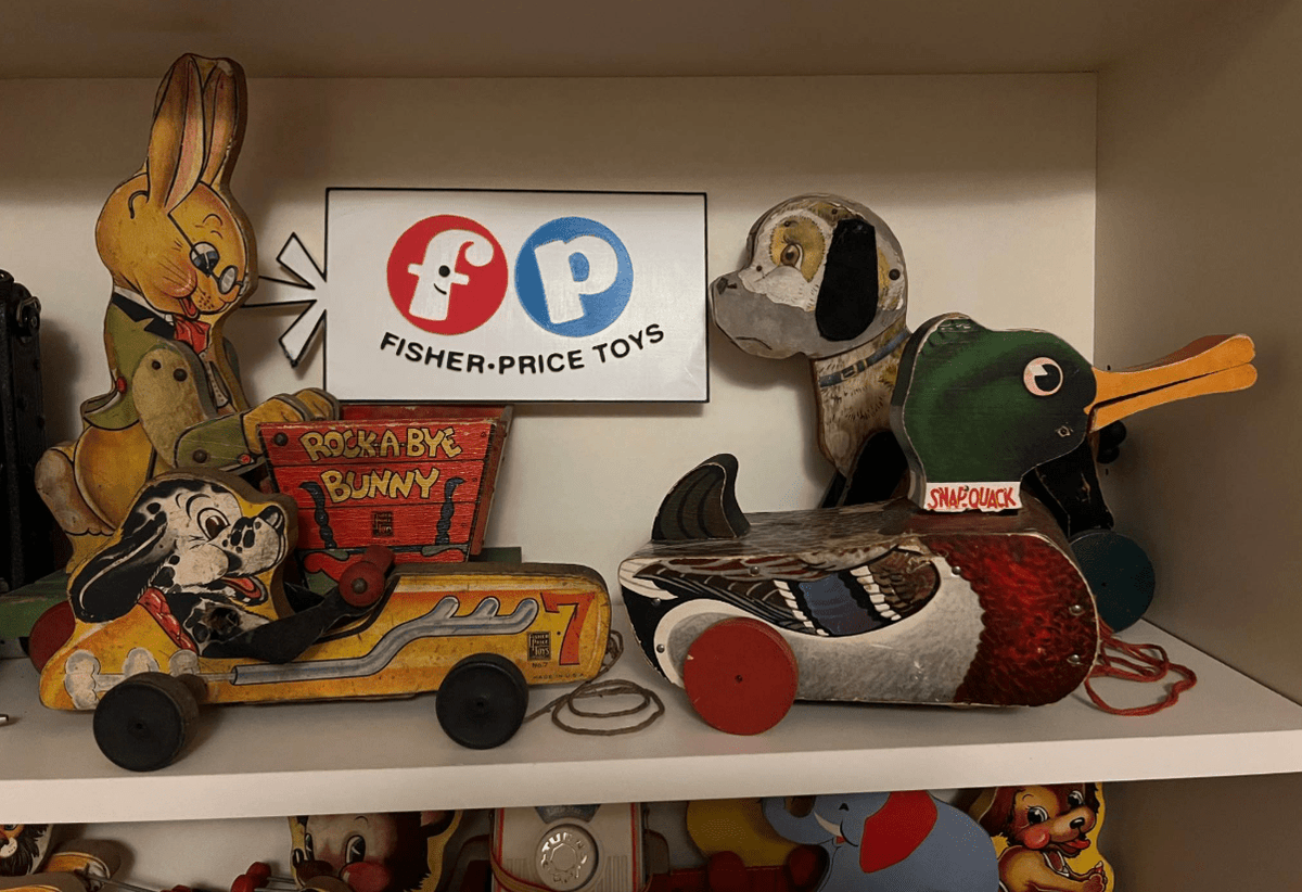 Retro Fisher-Price Toys display sign on wall with red F, blue P logos, and black wording